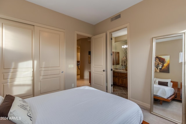 carpeted bedroom featuring ensuite bathroom, a closet, and sink