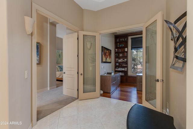 hall with light tile patterned flooring and french doors