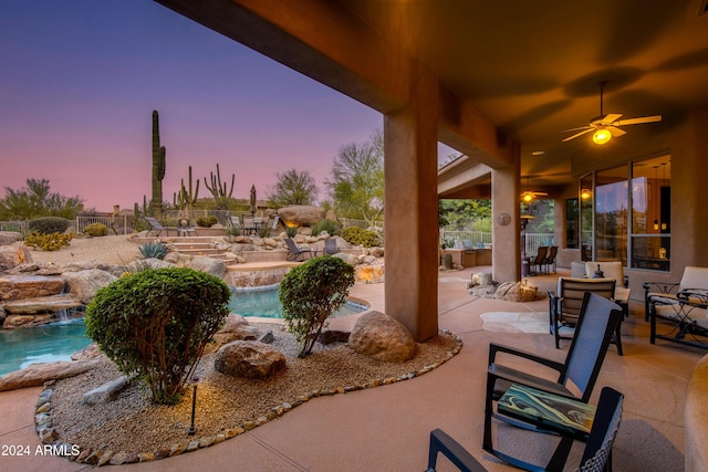 patio terrace at dusk with pool water feature and ceiling fan