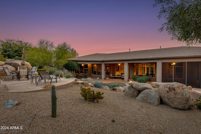 back house at dusk with a patio