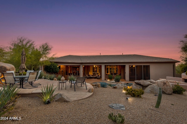 back house at dusk with a patio