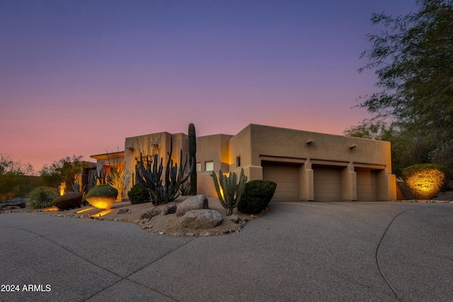 pueblo revival-style home with a garage