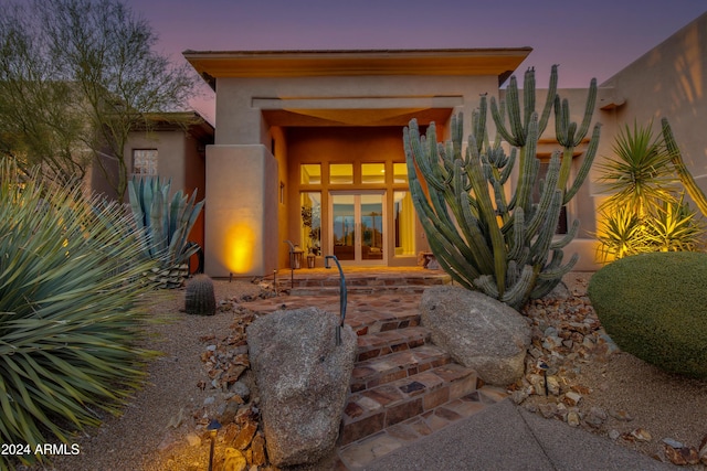 exterior entry at dusk featuring french doors