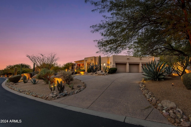 pueblo revival-style home featuring a garage