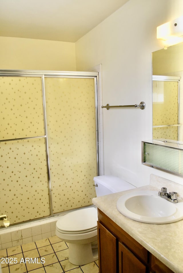 bathroom with walk in shower, vanity, toilet, and tile patterned flooring