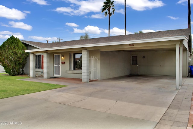 ranch-style home featuring a carport and a front lawn