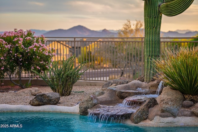10875 E Mirasol Cir, Scottsdale, AZ 85255 - pool at dusk featuring fence and a mountain view