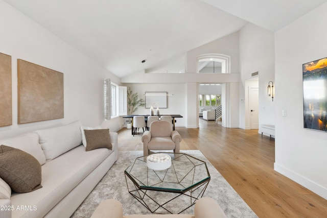 10875 E Mirasol Cir, Scottsdale, AZ 85255 - living room featuring high vaulted ceiling, baseboards, light wood finished floors, and visible vents