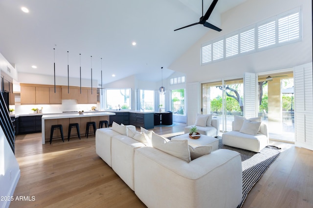 10875 E Mirasol Cir, Scottsdale, AZ 85255 - living area featuring plenty of natural light, a ceiling fan, light wood-style flooring, and high vaulted ceiling