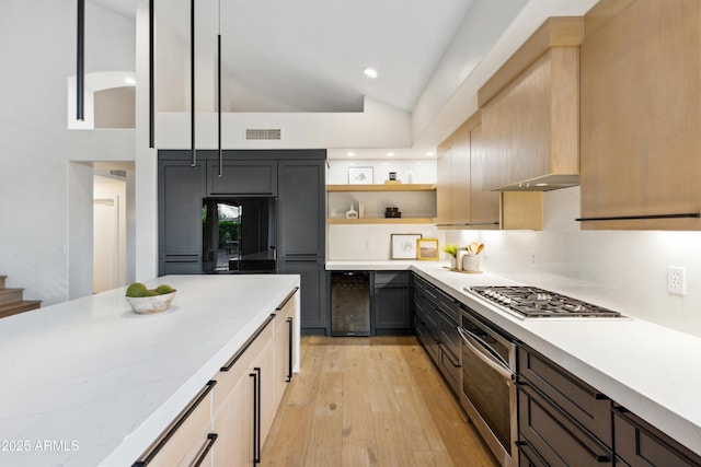 10875 E Mirasol Cir, Scottsdale, AZ 85255 - kitchen with visible vents, open shelves, beverage cooler, stainless steel appliances, and light wood-style flooring