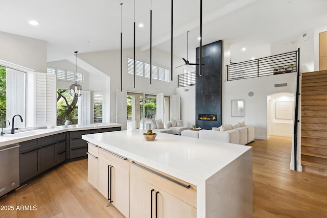 10875 E Mirasol Cir, Scottsdale, AZ 85255 - kitchen with a sink, light wood finished floors, high vaulted ceiling, gray cabinets, and a kitchen island