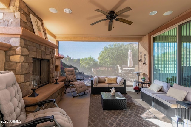 exterior space with ceiling fan, a fireplace, and a healthy amount of sunlight