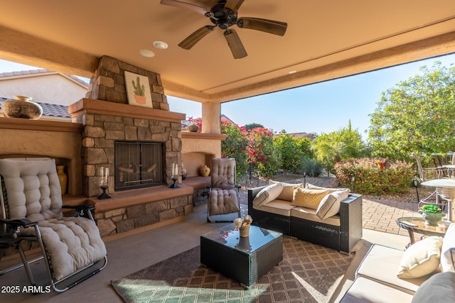 view of patio featuring ceiling fan and an outdoor living space with a fireplace