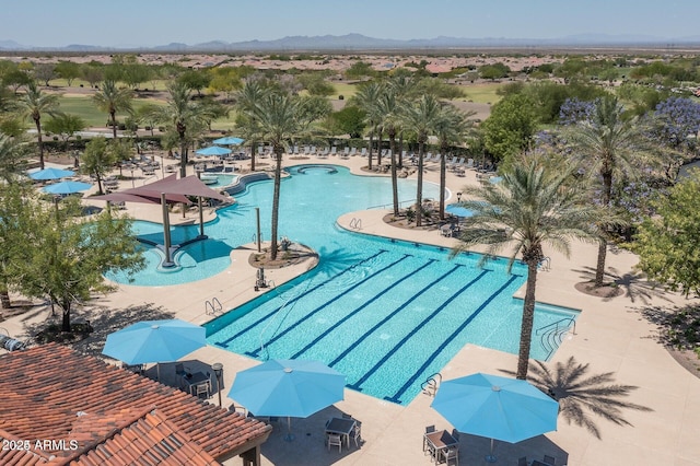 view of pool with a patio, a mountain view, and a grill