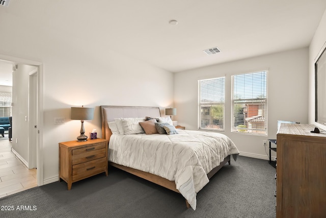 bedroom with baseboards, visible vents, and dark colored carpet