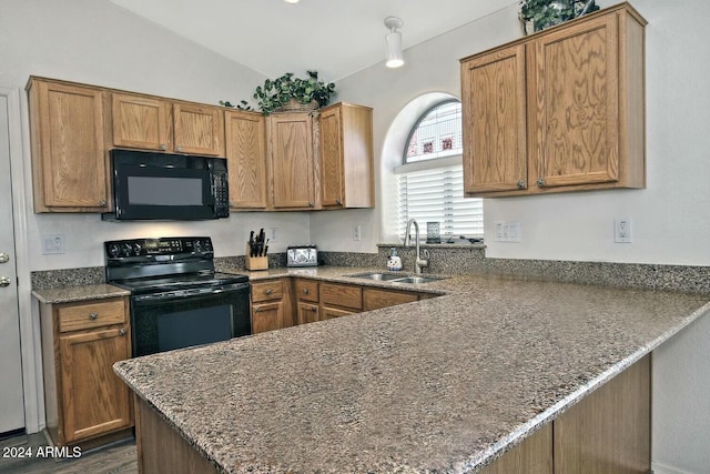 kitchen with kitchen peninsula, sink, black appliances, and lofted ceiling