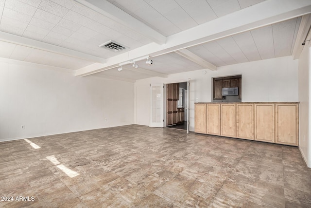 unfurnished living room featuring beamed ceiling