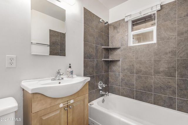 full bathroom featuring toilet, vanity, and tiled shower / bath