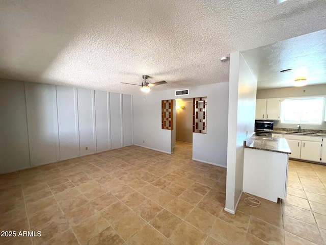 5342 E Des Moines St, Mesa, AZ 85205 - unfurnished living room with a textured ceiling, ceiling fan, and light tile patterned floors