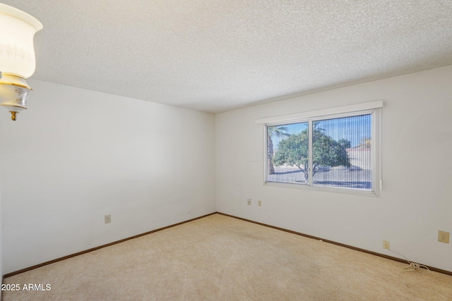 carpeted empty room featuring a textured ceiling