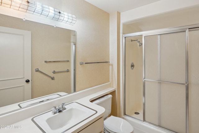 bathroom with sink, an enclosed shower, and toilet