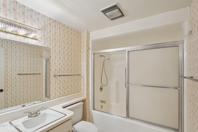 full bathroom with vanity, bath / shower combo with glass door, and toilet