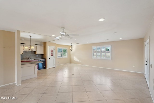 unfurnished living room with light tile patterned floors, ceiling fan, and sink