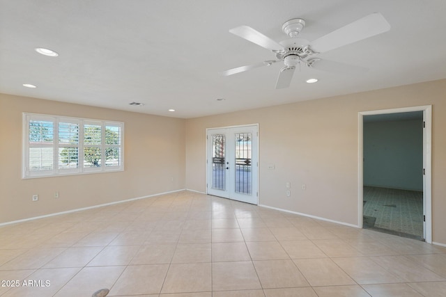 tiled spare room featuring ceiling fan and french doors