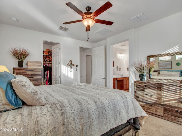 carpeted bedroom featuring connected bathroom, a spacious closet, ceiling fan, and a closet