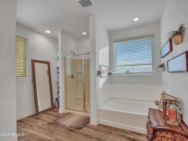 bathroom with separate shower and tub and hardwood / wood-style flooring