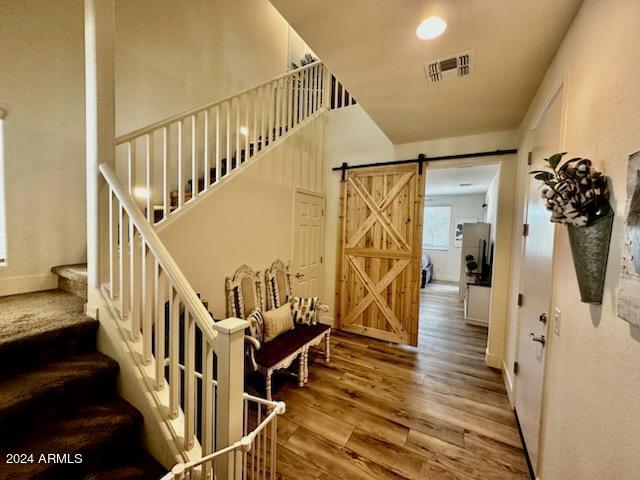 stairs with wood-type flooring and a barn door