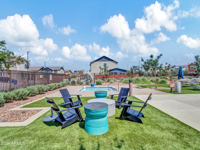 view of property's community featuring a lawn, a swimming pool, and a patio area