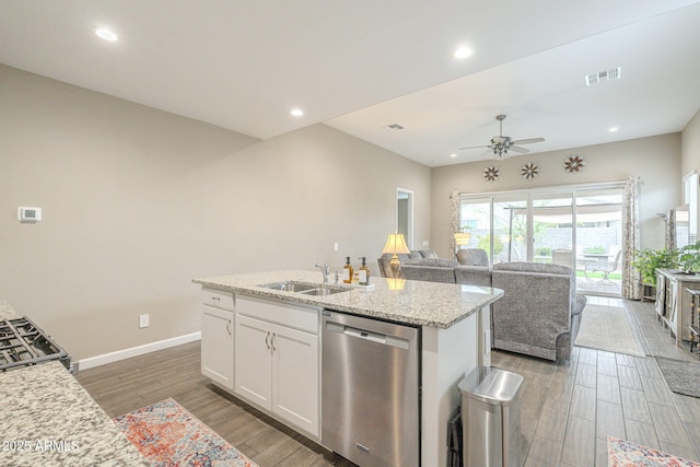 kitchen with visible vents, open floor plan, stainless steel dishwasher, white cabinets, and a sink