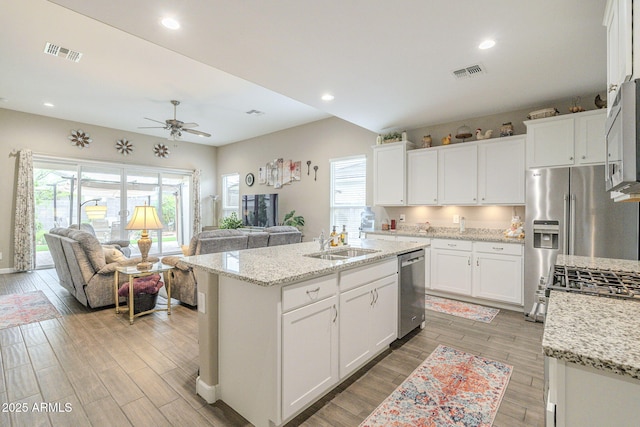 kitchen featuring open floor plan, visible vents, stainless steel appliances, and a sink