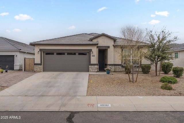view of front of house featuring stucco siding, stone siding, concrete driveway, and a tiled roof