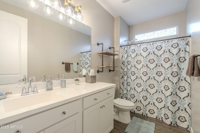 bathroom with curtained shower, toilet, wood finished floors, and vanity