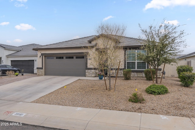view of front of house with stucco siding, a tile roof, stone siding, concrete driveway, and a garage