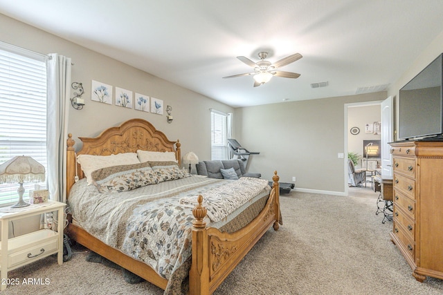 bedroom featuring visible vents, baseboards, light colored carpet, and a ceiling fan