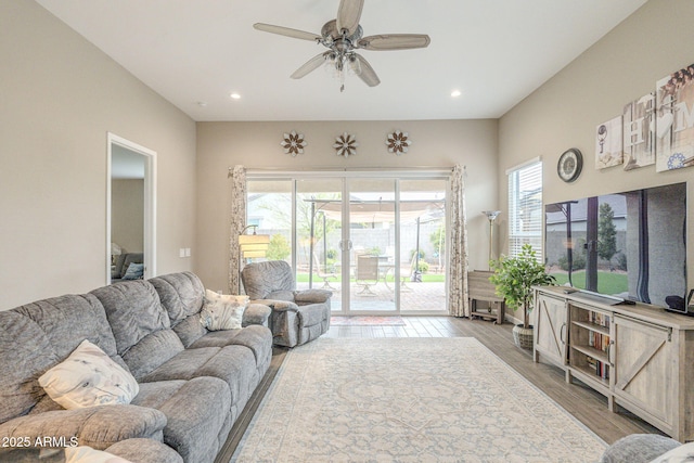 living area featuring recessed lighting, light wood-type flooring, and a ceiling fan