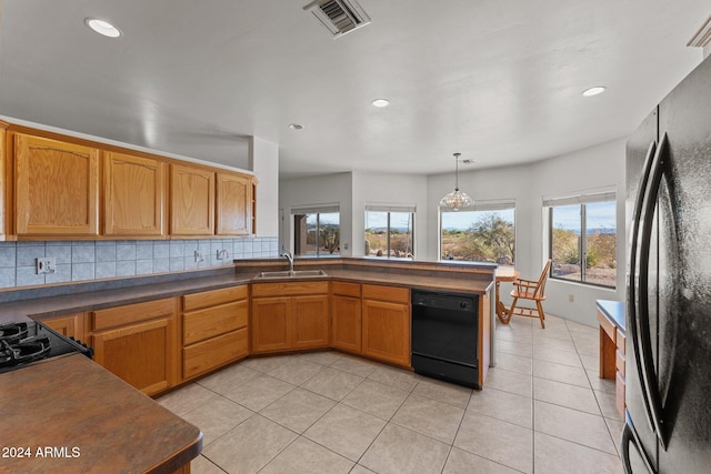 kitchen featuring black appliances, light tile patterned flooring, backsplash, decorative light fixtures, and sink