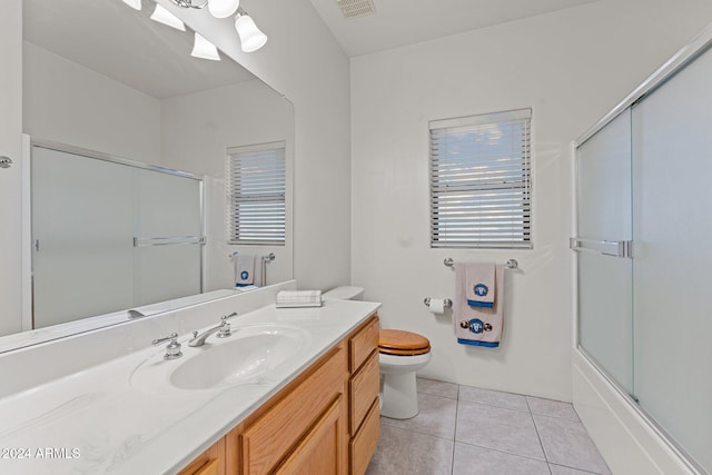 full bathroom featuring vanity, tile patterned floors, toilet, and a healthy amount of sunlight