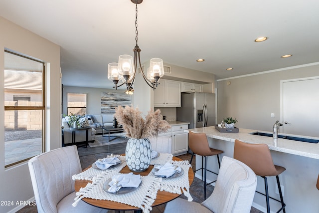 dining room featuring hardwood / wood-style flooring, a notable chandelier, sink, and crown molding