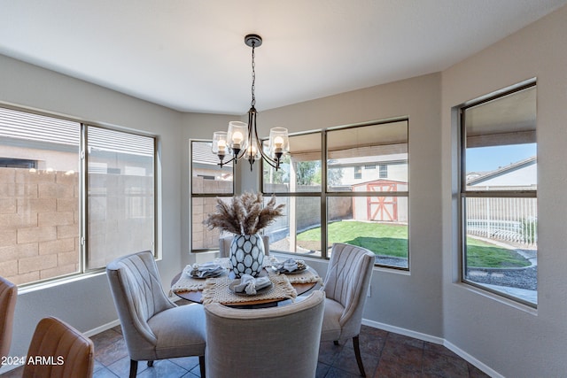 dining area featuring a chandelier and dark tile patterned floors