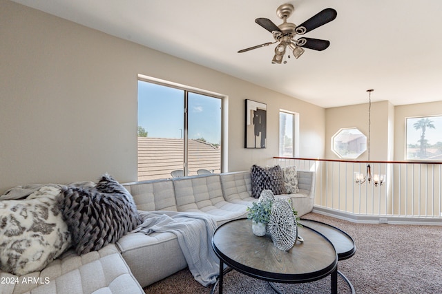 living room with carpet floors, ceiling fan with notable chandelier, and a wealth of natural light