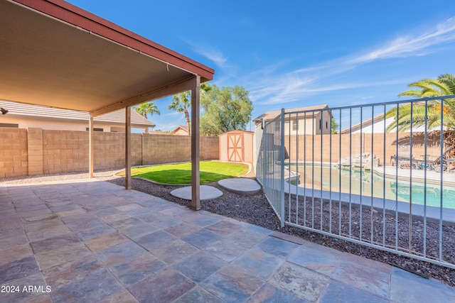 view of patio with a storage shed and a fenced in pool