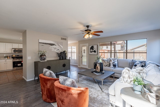 living room with dark wood-type flooring and ceiling fan