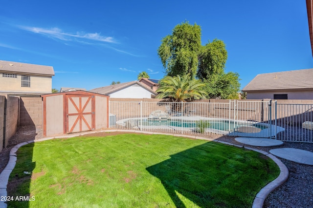 view of yard featuring a storage shed and a fenced in pool