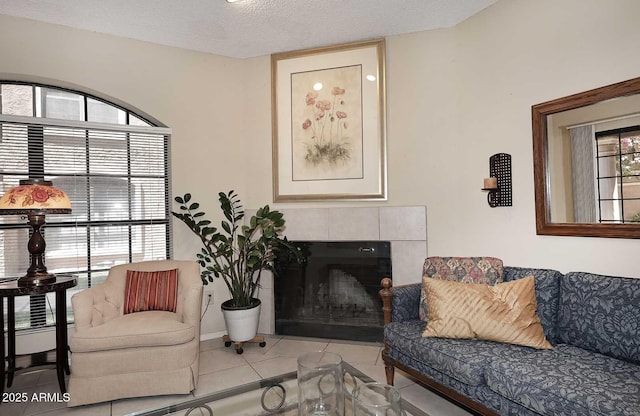 living area with tile patterned flooring, a textured ceiling, and a tile fireplace
