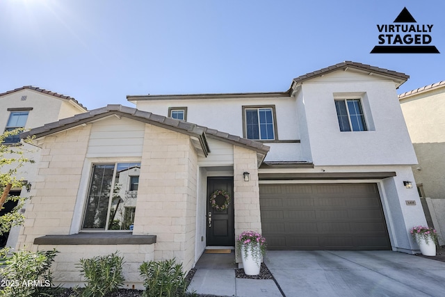 view of front of home featuring a tile roof, driveway, an attached garage, and stucco siding