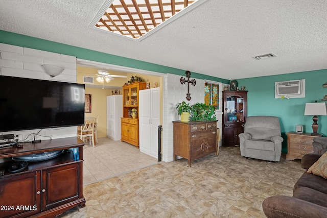 living room featuring a textured ceiling, a wall unit AC, and ceiling fan